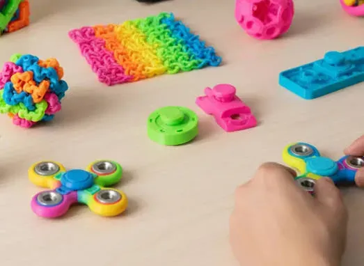 Fidget spinners, Pop Its and squishies on a table — custom fidget toy samples